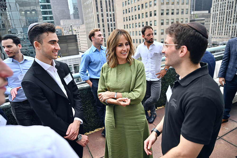 Audrey Weitz talks with male college students on Manhattan rooftop networking event
